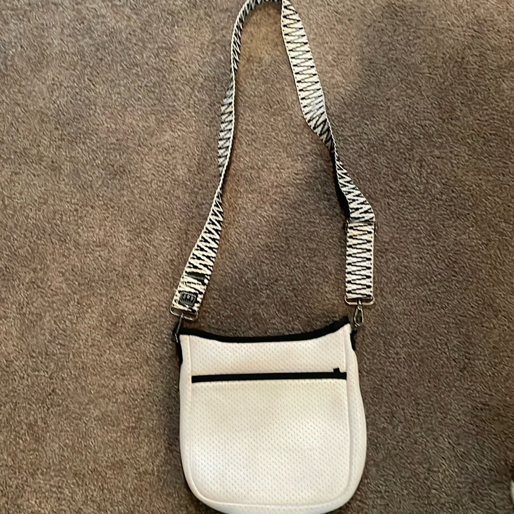 White Haute Shore purse with black and white strap